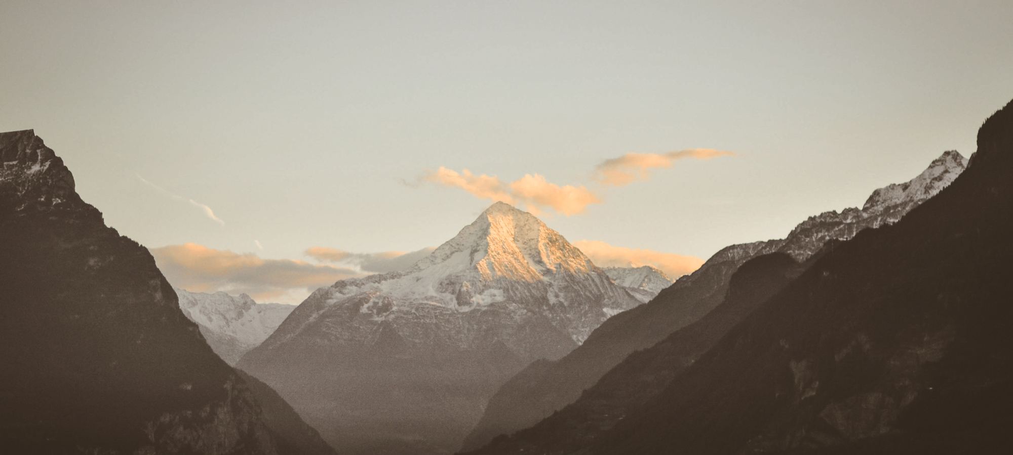 Snow-capped Alps above a lake at first light